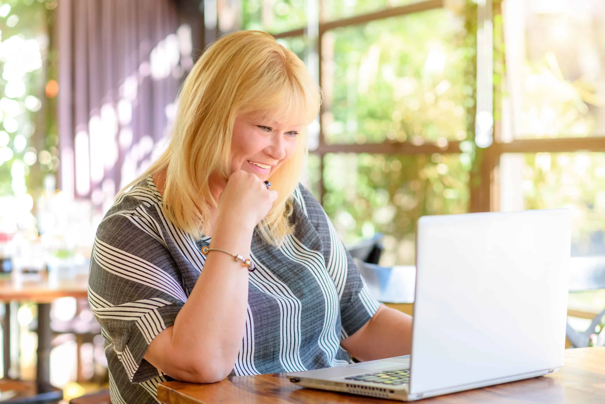 A patient planning at a laptop with a coffee