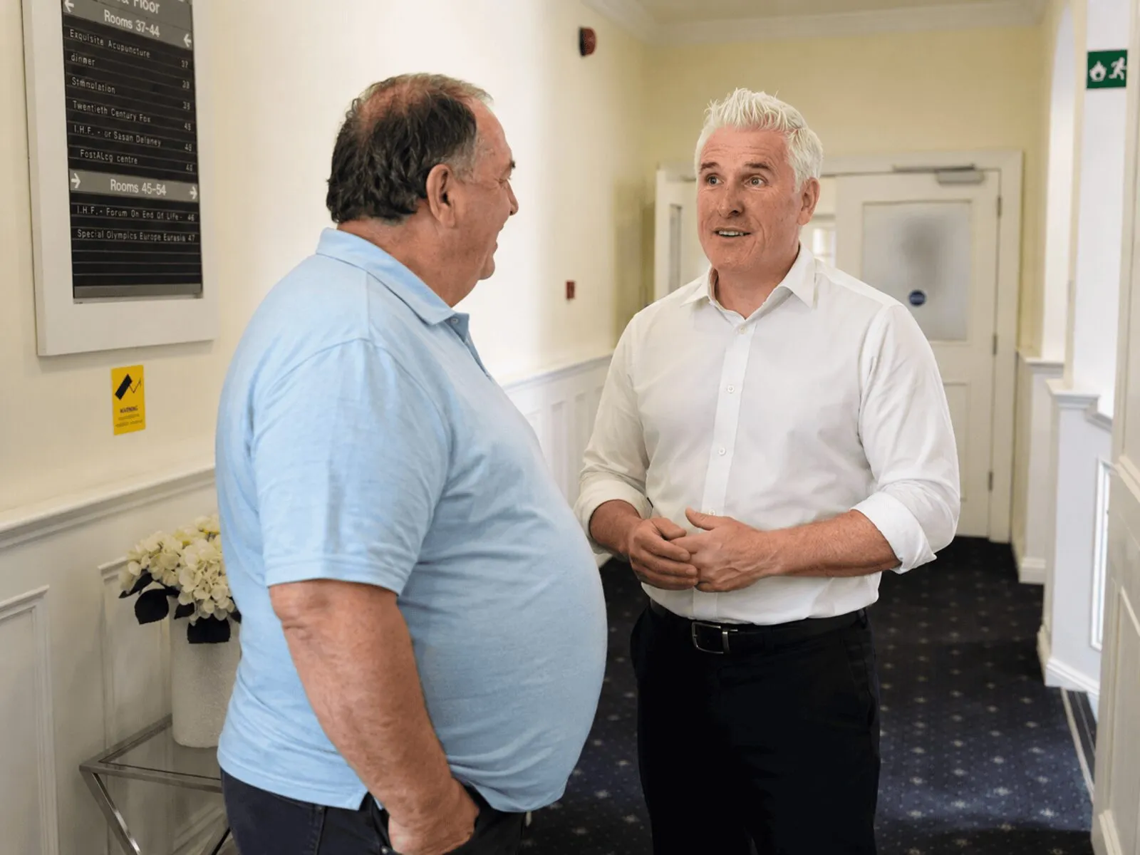 A patient arriving at the clinic and being greeted by his consultant