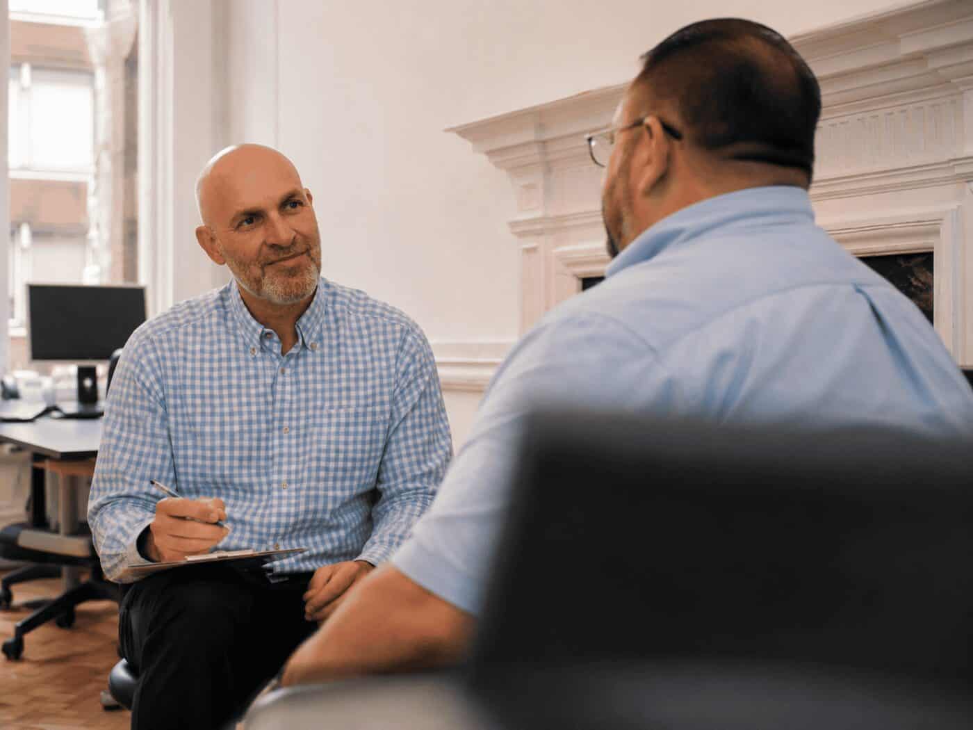 A Consultant Endocrinologist talking with a patient across the desk