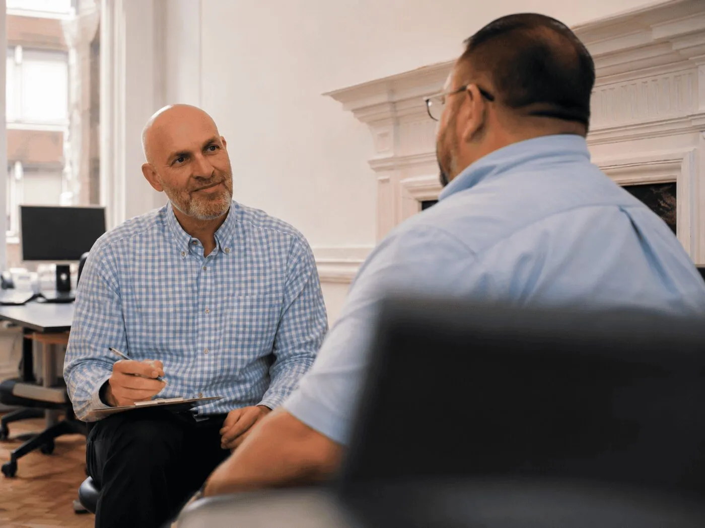 A Consultant Endocrinologist talking with a patient across the desk